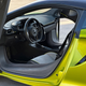View of the driver side of the interior of a Flux Green McLaren Artura with the door open.